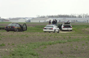 Law enforcement officers talk near the scene of a shooting Sunday afternoon northeast of Burkettsville. Mercer County Sheriff's Deputy Doug Timmerman shot Ricky Driskill, 27, of Columbus, who lunged at him with a construction knife. The victim remains under guard at Mercer County Community Hospital, Coldwater, while the deputy is on paid administrative leave during a subsequent investigation.<br>dailystandard.com