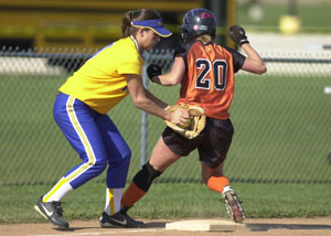 Minster's Erin Stueve, 20, races into third base safely just ahead of the tag from Marion Local third baseman Kelly Pleiman, left, during their Division IV sectional semifinal softball game at New Bremen. Minster went on to defeat Marion Local, 4-1.<br>dailystandard.com