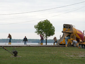 A group of workers prepares to pour cement this morning on the former Hawk property along Lake Shore Drive in Celina. The slab will serve as a new stage for the summer concert in the parks series. A new stage was necessary because crowds huddled around the left side of the old stage to keep the sun out of their eyes.<br>dailystandard.com