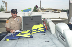 Grand Lake St. Marys State Park Officer Philip Centers checks life jackets on a boat at East Bank Marina in St. Marys. None of the three people who have drowned this year at state park lakes were using the safety devices.<br>dailystandard.com