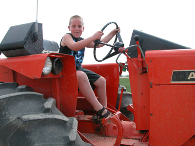 Mitchell Franzer, 7, of St. Henry, pretends to drive his dad's tractor on the family farm. The second-grader, born with spina bifoda, was chosen to appear on the Children's Miracle Network Celebration fund-raiser on WLIO-TV Channel 7 on Sunday between 1:50-2:20 p.m.<br>dailystandard.com