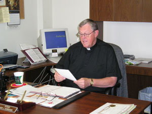 The Rev. Kenneth Schroeder works in his church office. He oversees the parishes of Sts. Rose, John the Baptist, Sebastian and Precious Blood and Nativity of the Blessed Virgin Mary churches. <br>dailystandard.com