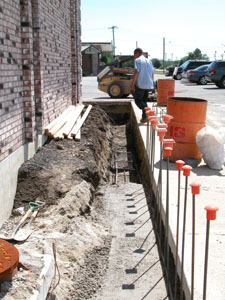 A worker finishes up for the day on the flood wall being constructed around the medical center south of Celina. Terrance Padden, CEO of Mercer Health, said the retaining wall should help protect the building from further flooding from the Beaver Creek. The building, which houses Doctors' Care, sustained about $1.5 million worth of damage during the Independ-ence Day flood of 2003.<br>dailystandard.com