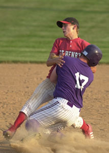 A Fort Recovery baserunner collides with St. Henry's Jay Woeste for an out between first and second base during their ACME contest on Tuesday at the Wally Post Athletic Complex.<br>dailystandard.com