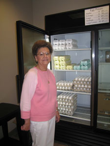 Lois Hemmelgarn, widow of former company president Floyd Hemmel-garn, stands at a cooler in the front lobby. The business, which supplies farm-fresh eggs to customers in the United States and overseas, also takes care of the needs of neighbors.<br>dailystandard.com