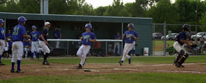 Grand Lake catcher Josh Eachues, 31, watches as teammates Dusty Hammond, 3, and Ryan Keena, 2, trot in together after Ben Gaal's triple in the third inning of Friday's game with Lake Erie. The Mariners improved to 9-5 with a 10-4 win over the Monarchs.<br>dailystandard.com