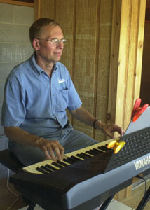 Jim Maurer plays a tune during a Grand Lake Mariners game at Jim Hoess Field in Celina. The church organist and retired math teacher has provided musical entertainment at home games since 1998.<br>dailystandard.com