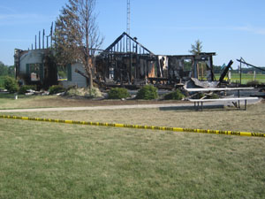 Yellow tape surrounds the home of Mark and Linda Schutz, whose 21-year-old son, Kevin, died in a fire at the home early Friday morning. The home was fully engulfed when firefighters arrived.<br>dailystandard.com