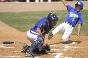 Grand Lake's Bryant Witt, 1, slides in safely at home plate as Lima catcher Sean Boley tries to make the catch on a low throw.<br>dailystandard.com