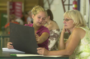 Sarah<br>Wenning<br>of Coldwater explains her<br>4-H genealogy project to<br>judge Diane Boeckman<br>during the interview process<br>last week. Projects<br>done by local<br>4-H members will be on display all next week during the Mercer County Fair, which starts Tuesday and runs through<br>Aug. 15.<br>dailystandard.com