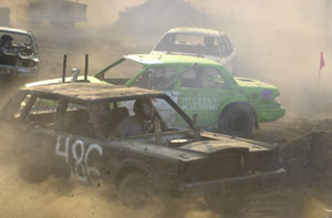 Cars race around a figure 8 track during the demolition derby at the Mercer County Fair on Tuesday. Along with the figure 8 race, there also was a demolition derby for 1977 and newer cars. Another demolition derby, for any full-size car, will be held at 7 p.m. Sunday. <br>dailystandard.com