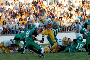 St. Marys running back Scott Laman, 9, runs through the middle of the St. Marys defense as Celina's Nick Gray, 8, and Adam Clutter, 70, tries to make the tackle. Laman had 116 yards on the ground to help St. Marys to a 32-20 victory over Celina on Friday night.<br>dailystandard.com