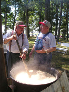 Gregor Kahlig of Fort Recovery listens as Larry Fennig of Celina, overseer of the bean soup cooking, gives some advice on the proper stirring of beans at the 107th Durbin Bean Bake. <br>dailystandard.com