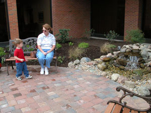 Two-year-old Alex Herzog of Wapakoneta and his grandmother, Judy McCune, pause for a while at the new Meditation Garden at Joint Township District Memorial Hospital, St. Marys. The garden was created in honor of recently retired hospital CEO and President Jim Chick. The plaque so designating is shown above.<br></br>dailystandard.com