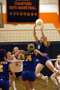 Marion Local's Maria Moeller, 9, sets the ball for teammate Jenna Barhorst, 14, as Versailles' Justine Raterman, 24, looks on.<br></br>dailystandard.com