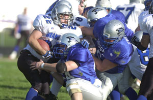 West Ohio's Brandon Meyer, 22, is gang-tackled by a group of Mercer County Cougars, led byJason Wenning, 64, and Dale Everman, 6. The Cougars held the Wranglers to minus 20 yards rushing in the 27-6 Mercer County win in the Interstate Football League playoff game.<br></br>dailystandard.com