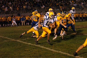 Marion Local quarterback Chris Stucke, 13, runs the ball as Delphos St. John's defender Michael Grubenhoff, 47, looks on during their game on Friday night. Delphos St. John's defeated Marion Local, 17-14.<br></br>dailystandard.com