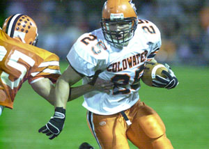 Coldwater's Ross Homan, 25, carries the ball and breaks a Versailles tackle during a matchup of top-ranked and undefeated teams. Coldwater, the top-ranked team in Division IV, defeated Versailles, the top team in Division V, on Friday, 31-21.<br></br>dailystandard.com