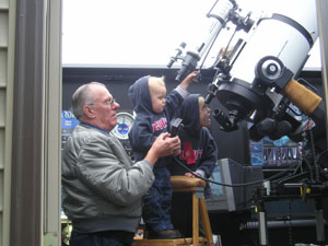 Amateur astronomer Bill Grunden of St. Marys helps his grandsons Carter, 2, and Wyatt Frey, 5, search the sky through his high-powered telescope. Mars is the observation target tonight, but these little guys will be sound asleep at 2 a.m. when the viewing is best.<br></br>dailystandard.com