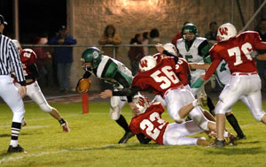 Celina quarterback Erik Chapin, left, fights for extra yardage during the Bulldogs' game against Wapakoneta on Friday night. Chapin became the first Celina player to pass and rush for 1,000-plus yards in the same season.<br></br>dailystandard.com