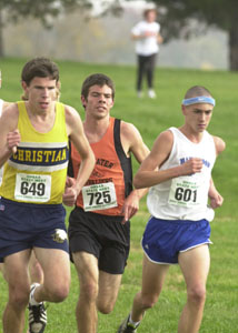 Coldwater's David Wilker, middle, runs between two competitors during the Division III boys state cross country meet on Saturday at Scioto Downs. Wilker finished in fourth place.<br></br>dailystandard.com
