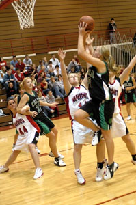 Celina's Liz Homan, with ball, shoots over a Wapakoneta defender while teammate Laura Link, on left, battles for position during Thursday's game. Celina lost in overtime, 60-58.<br></br>dailystandard.com