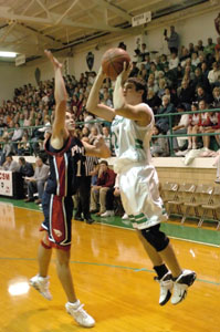 Celina freshman Derek Gagle, with ball, shoots in front of Piqua's Jeff Walker, left, during the season-opening game for both teams on Friday night at the Fieldhouse. Gagle scored a team-high 13 points but Piqua defeated Celina, 53-43.<br></br>dailystandard.com