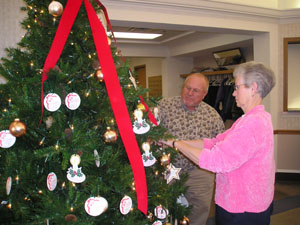 Joe and Judy McClanahan of St. Marys make some adjustments on the Tree of Hope at Otterbein St. Marys where they are residents.<br></br>dailystandard.com
