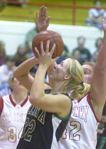 Celina's Laura Link, with ball, shoots in front of St. Henry's Gail Hartings, right, during their game on Tuesday night. Link scored 14 points to help the Bulldogs to a 59--57 win over the Redskins.<br></br>dailystandard.com