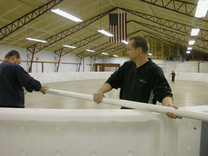 Mike Miller, left, and Bob Crouch work on one of the poles that holds the net for the new Wings~N~Wheels hockey rink at the Mercer County Fairgrounds in Celina. Miller and Crouch are members of Grace Missionary Church, which purchased the equipment for $20,000 for use by all area youths.<br></br>dailystandard.com