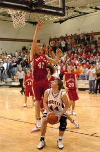 Minster's Logan Sommer, with ball, fakes out Houston's Dustin Schwable, 42, and drew a foul during their game on Friday night. Sommer scored all seven of his points in the second half to lead Minster to a 59-55 victory.<br></br>dailystandard.com