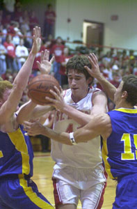 St. Henry's Kurt Huelsman, with ball, fights through a pair of Delphos St. John's defenders during their game on Tuesday night at Redskin Gymnasium. Huelsman scored 13 points and added nine rebounds in St. Henry's 51-49 win in overtime.<br></br>dailystandard.com