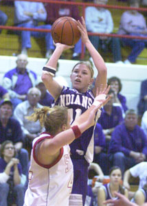 Fort Recovery's Tiffany Gaerke, with ball, shoots over St. Henry's Gail Hartings, front, during their game on Thursday night. Gaerke scored 18 points with 14 rebounds in the Indians' 59-52 win over the Redskins.<br></br>dailystandard.com
