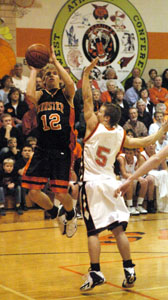 Minster's Jake Luttmer, 12, shoots over Versailles' Matt Murphy, 5, during their Midwest Athletic Conference contest on Friday. Minster defeated Versailles 52-50.<br></br>dailystandard.com