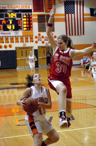 Coldwater's Tasha Stucke, with ball, comes to a stop as St. Henry's Kayla Lefeld, 30, jumps in the air during their game on Thursday night. The Cavaliers defeated the Redskins 37-29. <br></br>dailystandard.com