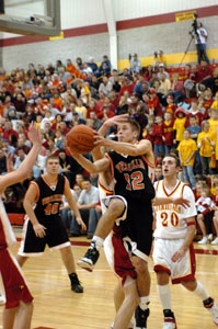 Versailles' Adam Barga, with ball, drives strong to the basket past a pair of New Bremen defenders during the Tigers' contest against the Cardinals on Friday. Barga scored a team-high 21 points but it wasn't enough as the Cardinals won, 68-66. <br></br>dailystandard.com