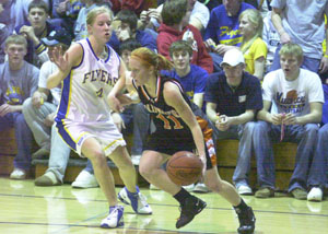 Coldwater's Renee Hemmelgarn, 11, is guarded closely by Marion Local's Holly Fortkamp, 4, during their Midwest Athletic Conference contest on Thursday night at The Hangar. Fortkamp and the Flyers upended the Cavaliers, 57-42.<br></br>dailystandard.com