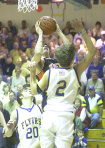 Minster's Andy Beckman, with ball, scores in front of Marion Local's Dan Moeller, 2, during their game on Friday night. Minster defeated Marion Local, 54-40.<br></br>dailystandard.com