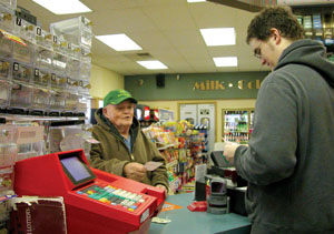 Kenny Laux of rural Celina waits in line at a store in Bryant, Ind., to receive Powerball lottery tickets from clerk Jason Meinerding on Thursday. The interstate Powerball game climbed to an all-time record $365 million jackpot for Saturday night's drawing, sending flocks of Ohioans into the Hoosier state seeking riches.<br></br>dailystandard.com