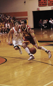 New Bremen's Allan Webster, with ball, tries to drive past Coldwater's Ryan Geier, left, during their game on Friday. New Bremen clinched at least a share of the Midwest Athletic Conference title with a 52-37 victory over Coldwater.<br></br>dailystandard.com