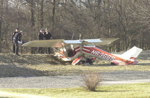 Officers investigate the scene where a 1967 Cessna model 150 G airplane piloted by Joel D. Avore of Greenville crashed near a Rockford home on Friday afternoon. He and his passenger, James A Canders of Wyoming, Mich., were both injured.<br></br>dailystandard.com