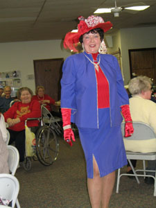 Lots of feathers and poufs decorate a hat modeled by Verah Barberine. Known as the Red Hat Queen, she collects hats and decorates them in red and purple fashion.<br></br>dailystandard.com