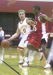 Brian Garman, 10, brings the ball up the floor for New Bremen as Lima Perry's Bentley Cooks, in red, defends during their Division IV district semifinal contest at Wapakoneta on Tuesday night.<br></br>dailystandard.com