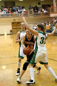 Versailles' Justine Raterman, with ball, tries to make a move past a pair of Anna defenders during the Tigers' regional semifinal contest on Wednesday night at Vandalia-Butler's Student Activity Center. Versailles defeated Anna, 44-40.<br></br>dailystandard.com