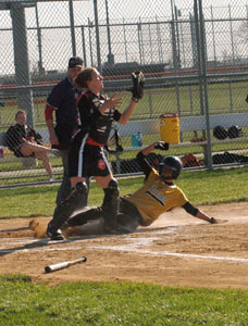 Parkway's Elaine Crowell, right, slides safely into home plate as Minster catcher Leslie Muhlenkamp, left, catches the ball from a teammate during their contest on Monday. Parkway defeated Minster, 10-1.<br></br>dailystandard.com