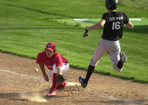 Celina's Scott Luthman, 16, hits first base safely before the ball bounces away from St. Henry first baseman Jon Clune, left, during their nonconference game on Thursday at the Wally Post Athletic Complex. Celina upset the state-ranked Redskins, 9-7.<br></br>dailystandard.com