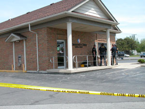 Members of the St. Marys and Cridersville police departments and the Auglaize County Sheriff's Office confer outside the Community First Bank & Trust office on Celina Road in St. Marys following an armed bank robbery late Tuesday morning. No one was hurt and the suspect remained at large at press time today.<br></br>dailystandard.com