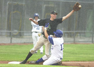 Celina's Eric Loughridge, left, stretches for the ball as Anthony Wayne's Miguel Flores, 13, slides into third base during their Division I sectional contest at Carter Field in Bowling Green. Anthony Wayne holds an 8-3 lead at this point with the game being suspended in the fifth inning. The game will be finished today, weather permitting, at 5 p.m. at Bowling Green.<br></br>dailystandard.com