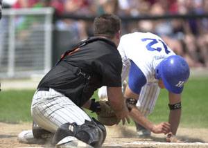Versailles catcher Alex Davis, left, lunges to tag out Sparta Highland's Gar Keen, right, at the plate during Division III regional final action at Centerville on Saturday. Sparta Highland defeated Versailles, 3-2. <br></br>dailystandard.com
