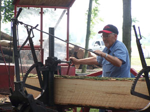 Head sawyer Tom Stephens, Arcanum, aligns a log to be cut by steam power on July 4. Stephens is the saw mill operator for the week at the Darke County Steam Threshers 50th Reunion.<br></br>dailystandard.com